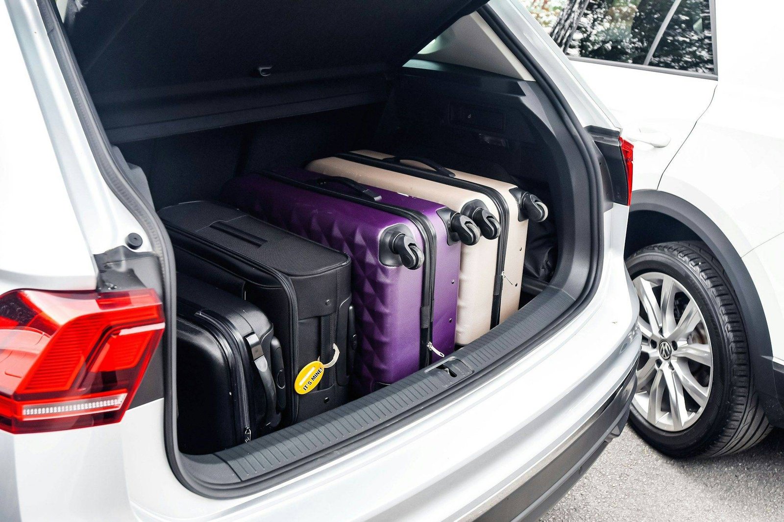 Valises chargées dans le coffre d'une voiture avant un départ en vacances, vérifications avant un long trajet