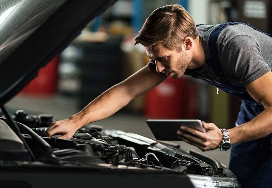 Mécanicien inspectant une voiture dans un garage à Vigneux-sur-Seine, effectuant un diagnostic automobile avant une réparation voiture.